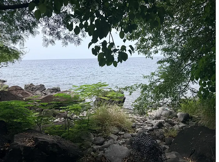 Débouché du sentier sur le rivage de galets et de roches